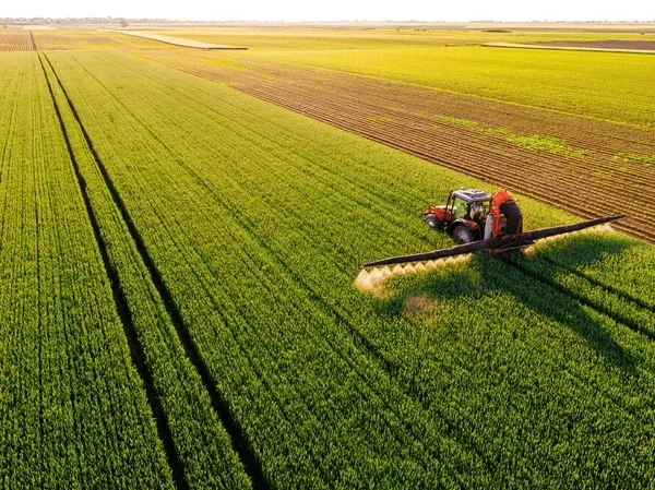 drone-shot-tractor-spraying-lush-600nw-2464594961